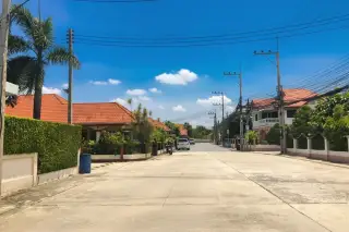 Country Club Villa street view with houses, red tiled roofs, palm trees, and overhead power lines.