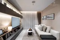 1 Bedroom Condo for Sale at Panora Estuaria: Living room with a long sofa, large TV, and floor-to-ceiling curtains.