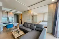 1 Bedroom Condo for Sale at Cetus Beachfront modern living room with grey sofa, dining area and open bedroom partition