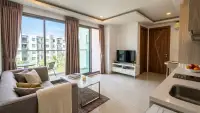 2 Bedroom Condo for Sale at Arcadia Beach Resort living room with TV console and floor-to-ceiling windows
