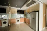 3 Bedroom Condo for Sale at Apus modern kitchen with wood cabinets, glass backsplash, stainless fridge, and two washing machines