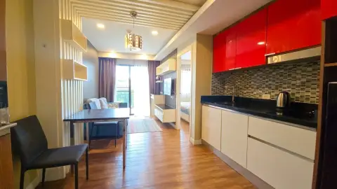 1 Bedroom Condo for Sale at Dusit Grand Park 1 red gloss kitchen cabinets beside dining table and living room