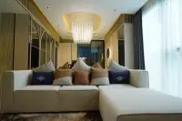 2 Bedroom Condo for Sale at SKYPARK Lucean Jomtien Pattaya elegant living room with crystal chandelier and white L-shaped sofa