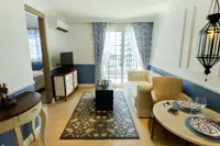 1 Bedroom Condo for Sale at Seven Seas Cote d'Azur, living room with sofa, TV console, and balcony access.