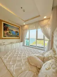 2 Bedroom Condo for Sale at Del Mare bedroom with framed artwork, draped curtains and ocean view window