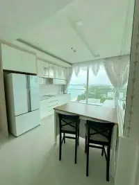 2 Bedroom Condo for Sale at Del Mare modern kitchen with white cabinetry, fridge and breakfast bar seating