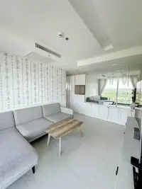 2 Bedroom Condo for Sale at Del Mare living room with gray sectional sofa, wooden coffee table and mirrored wall