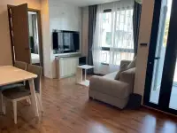 2 Bedroom Condo for Rent at Dormy Residences Sriracha living room with dining table, TV console and balcony door