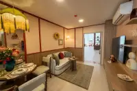 1 Bedroom Condo for Sale at D Condo Vite open-plan living and dining area with retro pink decor, sofa and pendant light