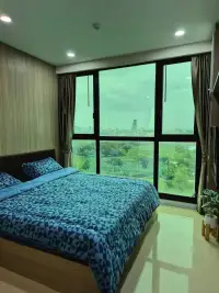 1 Bedroom Condo for Rent at Dusit Grand Condo View bedroom with blue bedding and large window overlooking cityscape