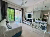 1 Bedroom Condo for Sale at Dusit Grand Condo View living room with sofa, TV unit, and balcony access