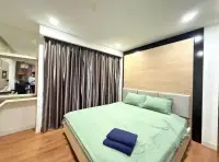 1 Bedroom Condo for Rent at Dusit Grand Park 1 bedroom with green bedding and sliding glass door to balcony