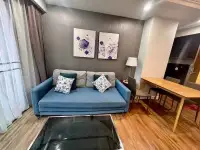2 Bedroom Condo for Rent at Dusit Grand Park 1 living room with blue sofa and modern wall art
