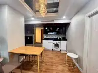 2 Bedroom Condo for Rent at Dusit Grand Park 1 dining area with wooden table next to compact kitchenette