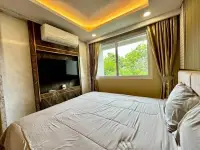 1 Bedroom Condo for Rent at Dusit Grand Park 2 bedroom with wall-mounted TV and marble feature wall