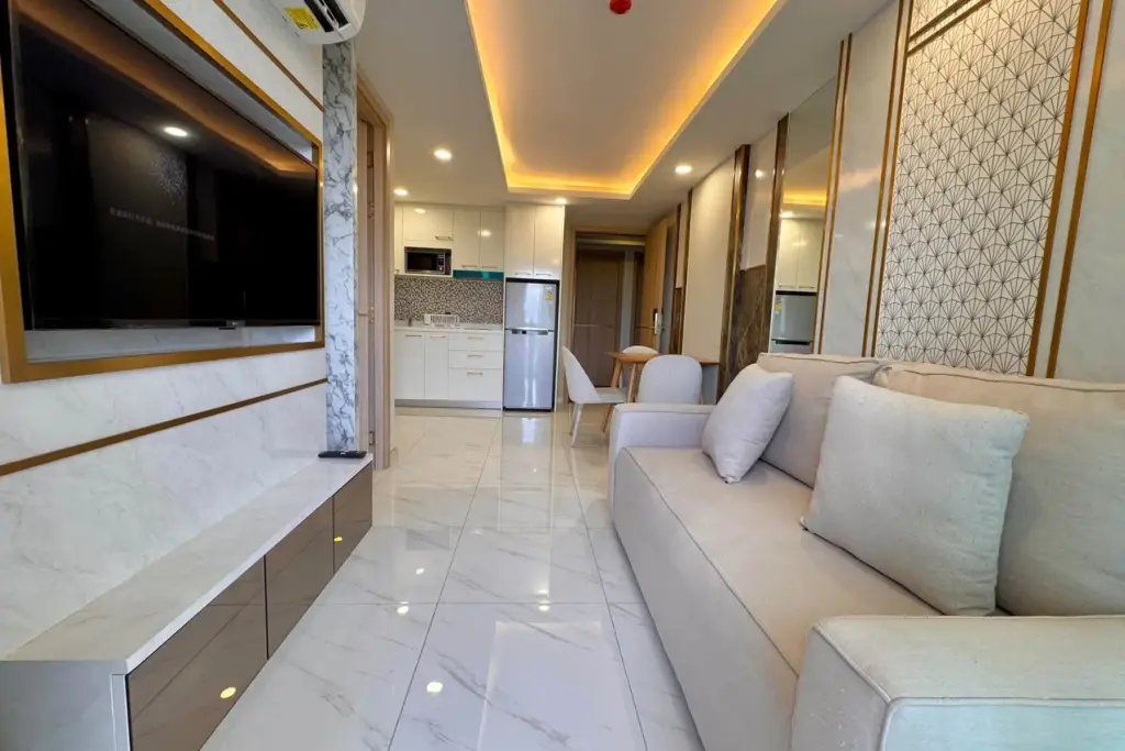 1 Bedroom Condo for Sale at Dusit Grand Park 2 living room with wall-mounted TV, kitchen and dining area view