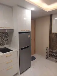 1 Bedroom Condo for Sale at Dusit Grand Park 2 kitchen with stainless steel fridge, white cabinets and tiled backsplash