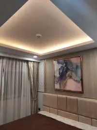 1 Bedroom Condo for Sale at Dusit Grand Park 2 bedroom with tray ceiling lighting and abstract art above headboard