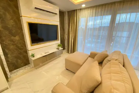 2 Bedroom Condo for Rent at Dusit Grand Park 2 lounge area with marble accent wall, mounted TV, and plush sofa