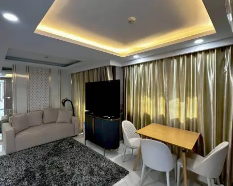 3 Bedroom Condo for Rent at Dusit Grand Park 2 living room with flat-screen TV, sofa and gold curtains