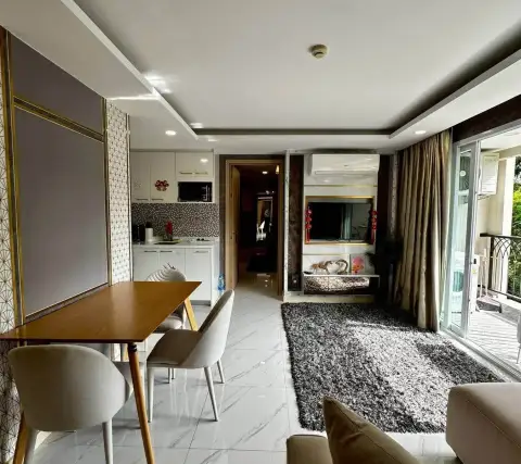 3 Bedroom Condo for Rent at Dusit Grand Park 2 open-plan living space with balcony access and kitchen view