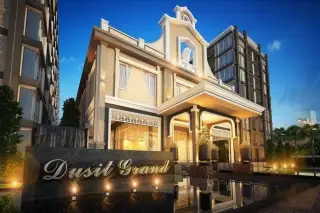 Dusit Grand Park 2 main building entrance at night, with illuminated Dusit Grand sign and water feature.