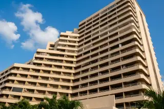 Angket Condominium outdoor swimming pool with light blue water and building facade with balconies in the background.