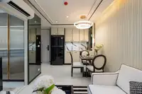 1 Bedroom Condo for Sale at Embassy Life open-plan kitchen and dining area with black refrigerator and white cabinets.