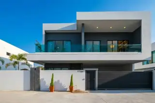 Enchant Villa modern two-story house with swimming pool, wooden deck, and covered carport with two cars.