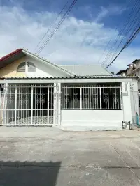 2 Bedroom Townhouse for Rent at Eakmongkol 4 white exterior facade with metal security gates and tiled roof