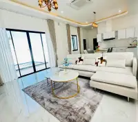 3 Bedroom House for Sale in East Pattaya bright living room with white sectional sofa and pool view