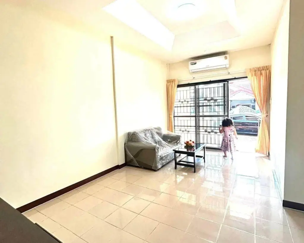 2 Bedroom House for Rent in East Pattaya bright living room with plastic-wrapped sofa and skylight