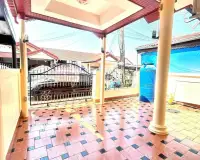 2 Bedroom House for Rent in East Pattaya gated driveway entrance with parked car and neighborhood view