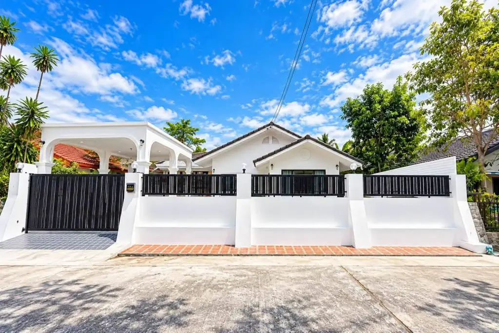 3 Bedroom House for Sale in East Pattaya white exterior with black sliding gate and covered carport