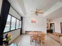 3 Bedroom House for Rent in East Pattaya dining area with wooden table, ceiling fan and large window