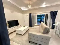 3 Bedroom House for Rent in East Pattaya living room with beige sofa, TV unit and garden view
