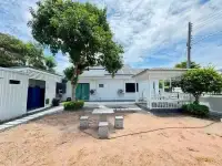 3 Bedroom House for Sale in East Pattaya backyard with shade tree, solar roof panels, and seating area
