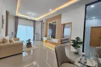 3 Bedroom House for Sale in East Pattaya open-plan living room with marble feature wall and bedroom view
