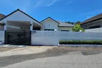 3 Bedroom House for Sale in East Pattaya front view with black gate, carport and garden hedge