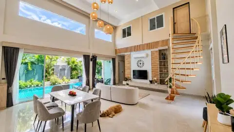 3 Bedroom House for Rent in East Pattaya bright living room with spiral staircase, sofa and dog relaxing by pool view