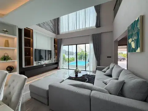 4 Bedroom House for Sale in East Pattaya spacious living area with built-in TV unit and sliding doors to pool