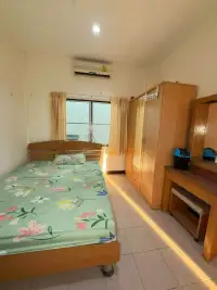 2 Bedroom Townhouse for Rent in East Pattaya bedroom with floral bedspread, wooden wardrobe, and air conditioner