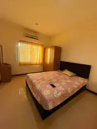 2 Bedroom Townhouse for Rent in East Pattaya master bedroom with double bed, wardrobe, and curtained window