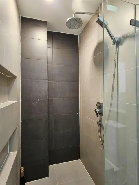 1 Bedroom Condo for Sale at Acqua Condo glass-enclosed rain shower with dark tile accent wall