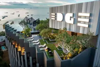EDGE Central Pattaya: Property entrance sign with gold 'EDGE Central Pattaya' lettering on a dark stone wall.