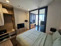 1 Bedroom Condo for Sale at EDGE Central Pattaya bed facing open closet and kitchenette with balcony view