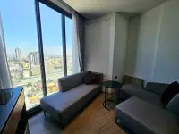 1 Bedroom Condo for Sale at EDGE Central Pattaya living area with gray sofas and panoramic city view