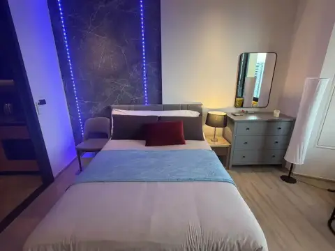 Studio Condo for Rent at EDGE Central Pattaya bedroom with LED-lit marble headboard and grey dresser