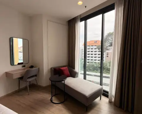 Studio Condo for Rent at EDGE Central Pattaya lounge chair by floor-to-ceiling window with city skyline view