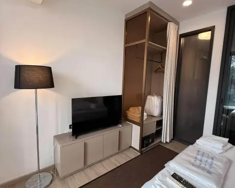 Studio Condo for Rent at EDGE Central Pattaya TV cabinet beside open closet with folded towels and safe